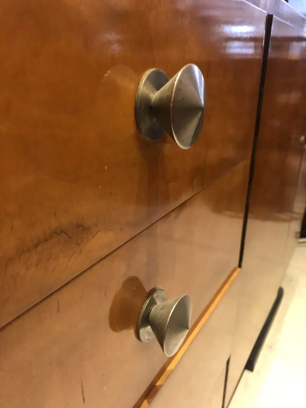 antikes bücherregal mit metallknöpfen in einem warmen raum