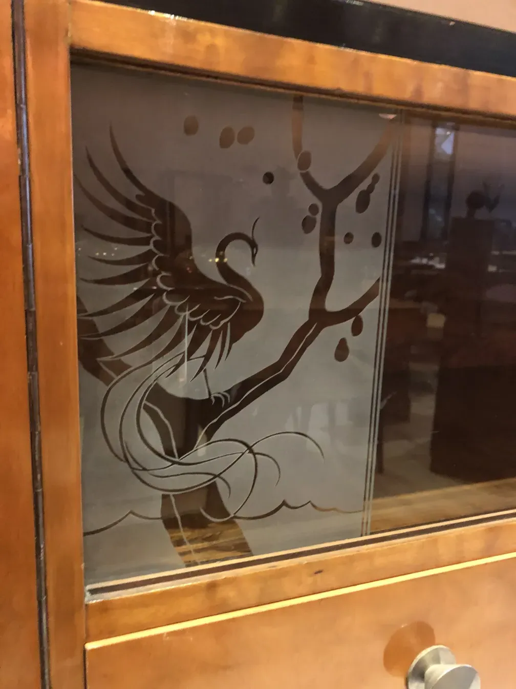 Altes Bücherregal mit Vogeldesign an der Tür.