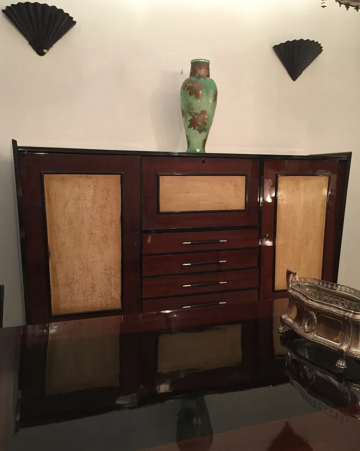 Antique bookcase with shelves and floral decor.