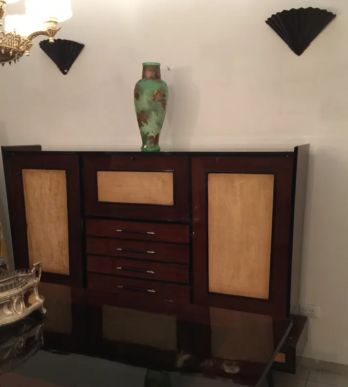 Libreria antica in legno con dettagli decorativi e un vaso verde sopra