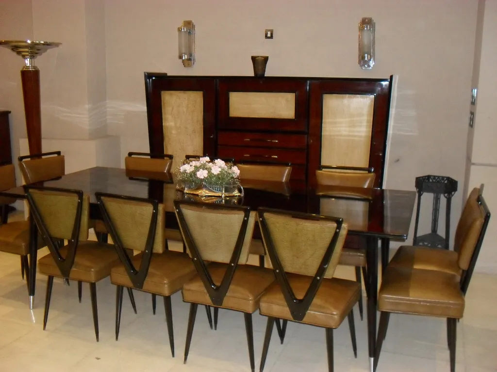 Antique wooden bookcase with elegant details, surrounded by chairs and soft lighting.