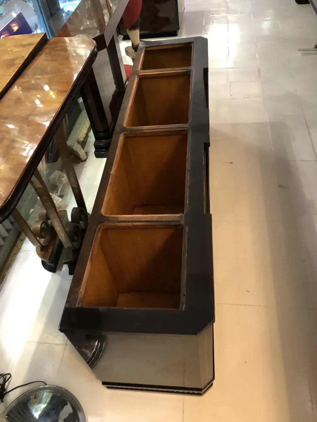 Antique bookcase with shelves of varied sizes and decorative details, in a classic setting.