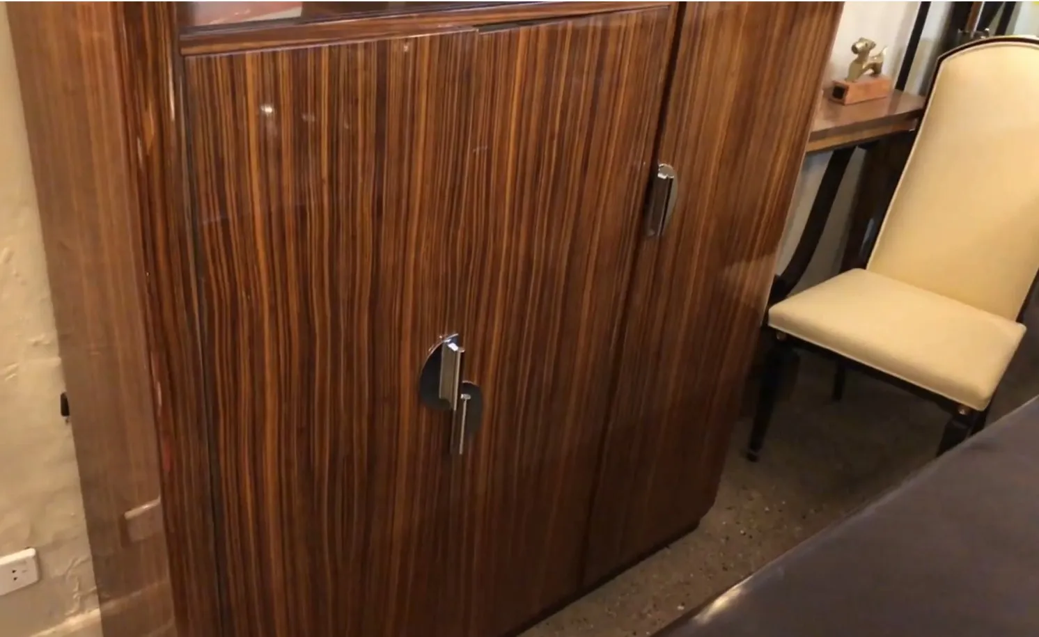 Bibliothèque ancienne en bois sombre avec des accents brillants, dans un environnement classique.