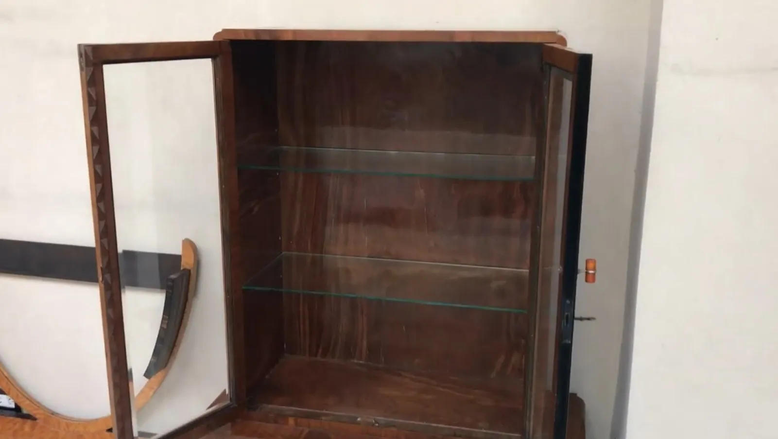Antique bookcase with glass shelves, stylish and functional.