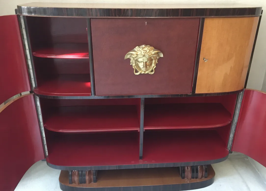 Antique bookcase featuring red shelves and gold detail