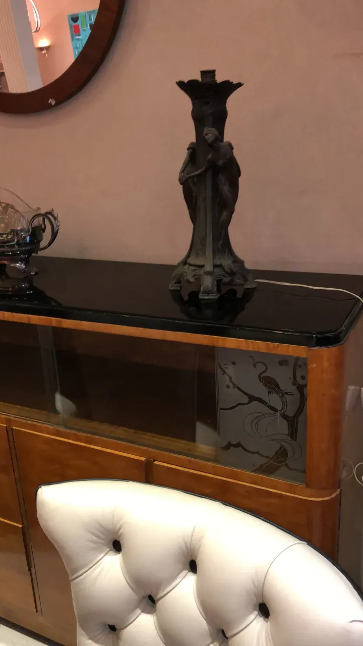 Antique bookcase with decorative statue in the setting.