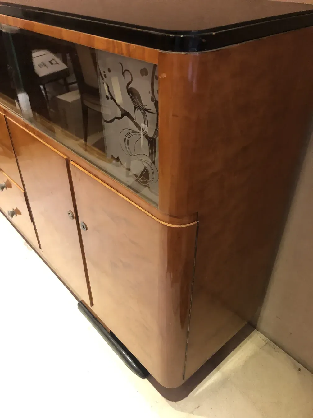 Alter Bücherregal mit dekorativen Glasfenstern an der Vorderseite.