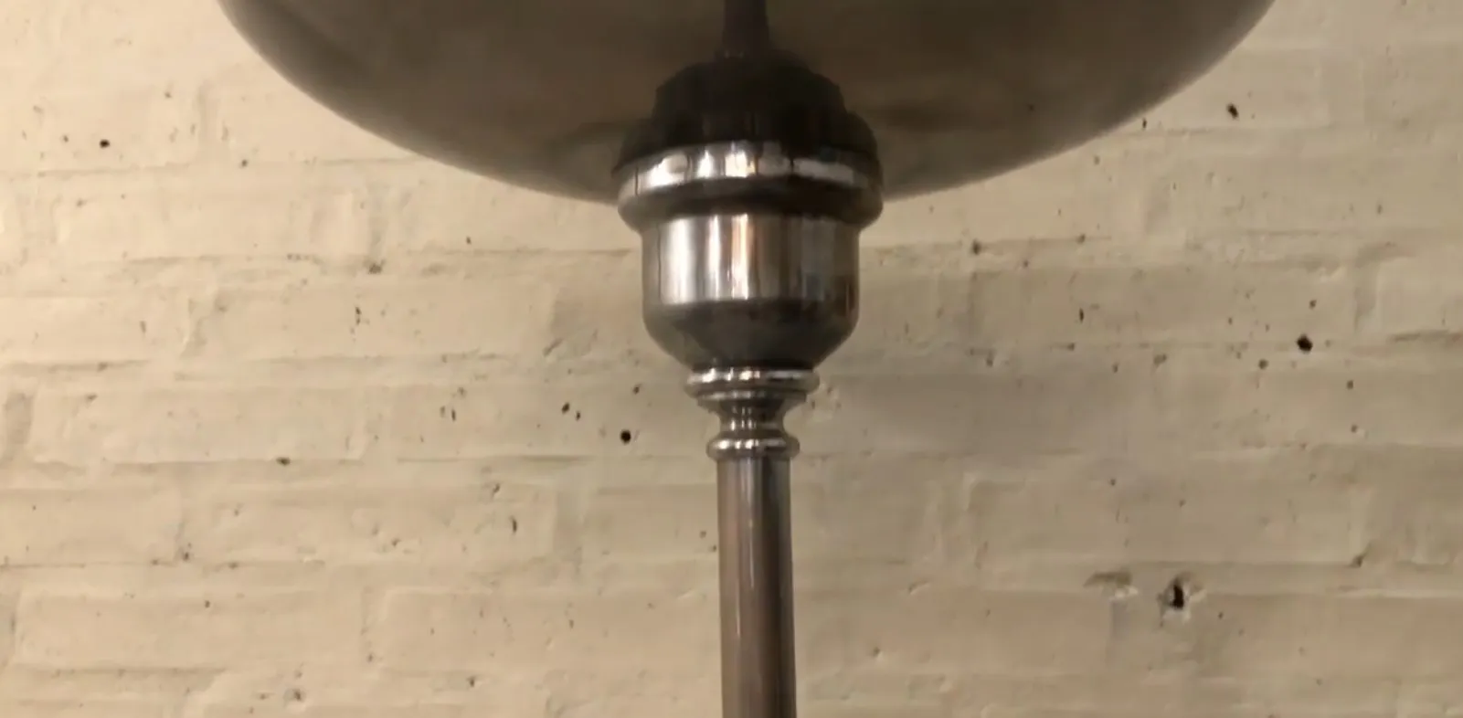 lampara de pie antigua con base decorativa en un ambiente acogedor