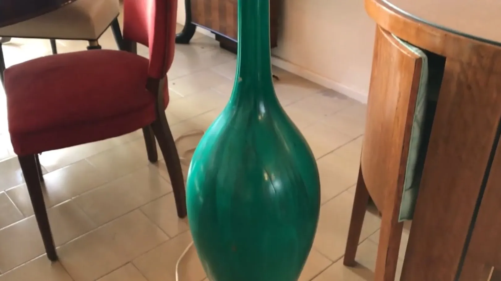 Antique green floor lamp in a room with red chairs