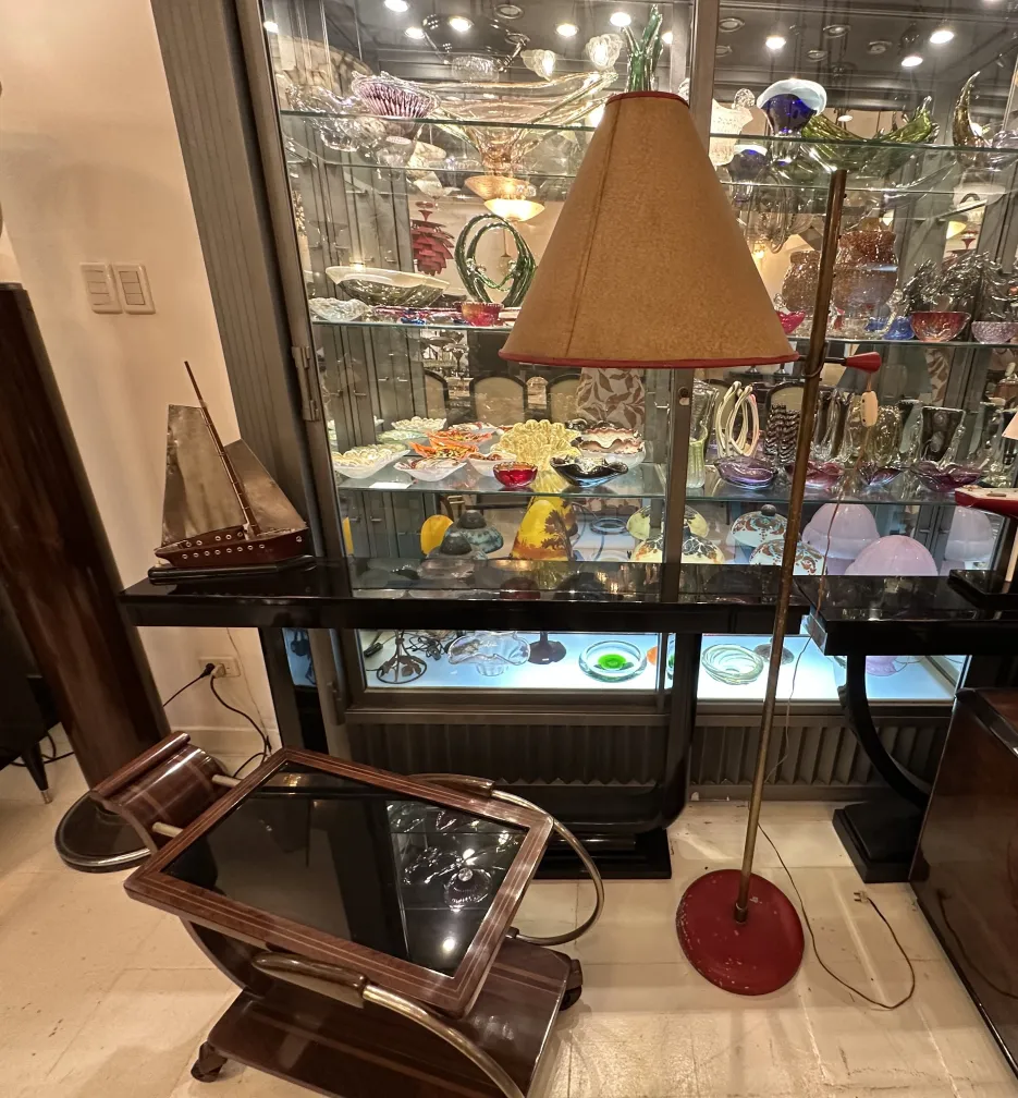 Luminária de pé antiga com base vermelha e cúpula bege em um ambiente elegante