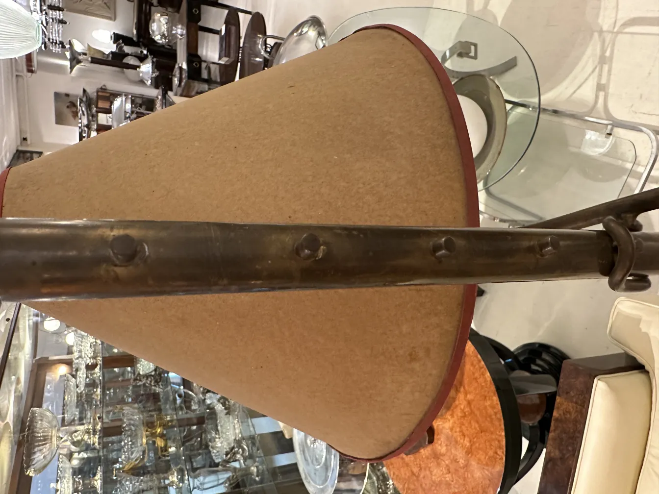 Antike Stehleuchte mit konischem Schirm und Metallbasis in einem eleganten Ambiente.