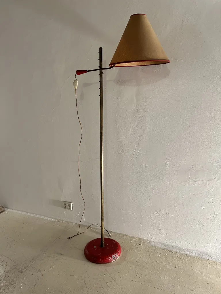 Antique floor lamp with red base, simple environment.