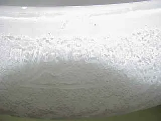 Lámpara de pie antigua de cerámica blanca con textura sutil, ideal para decoración.