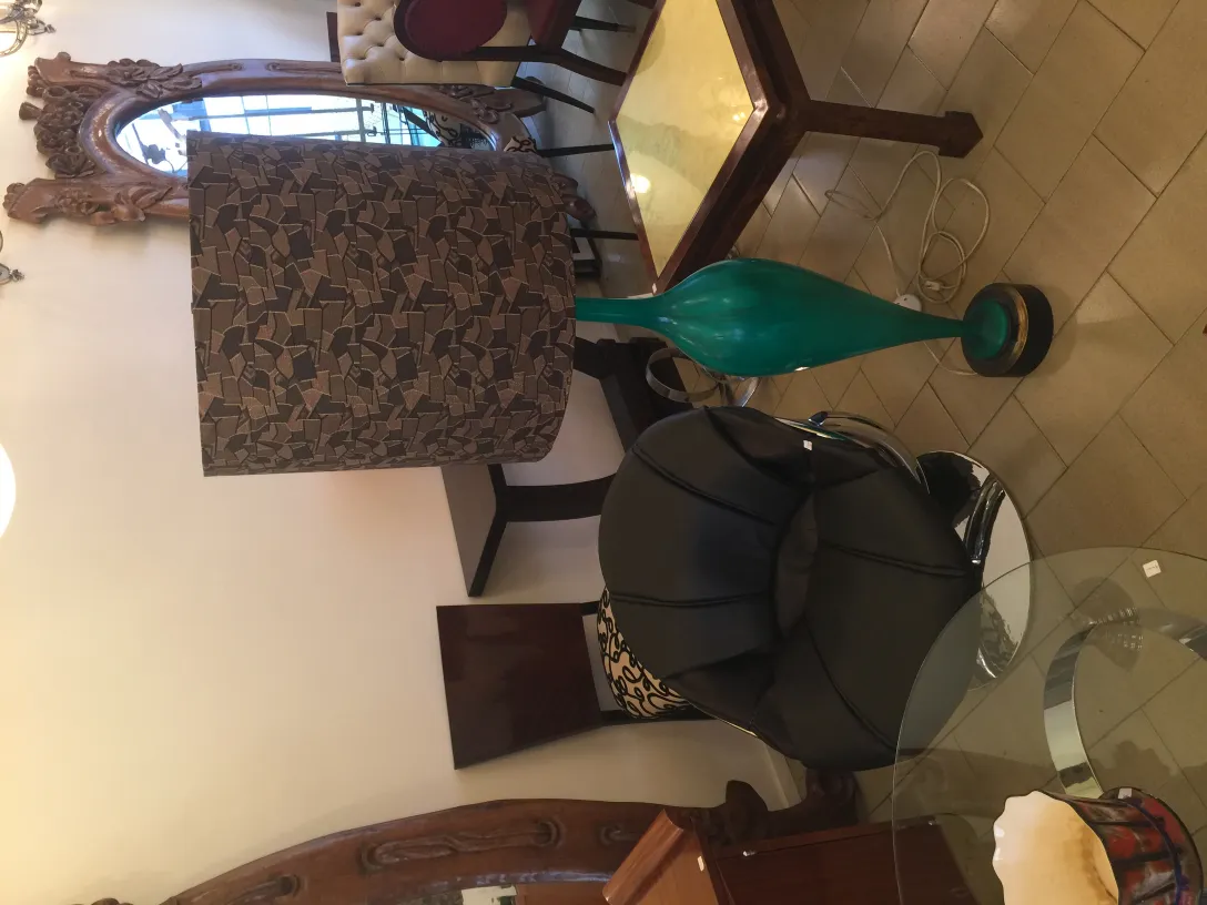 Antique floor lamp with green base and decorative shade in a cozy setting.