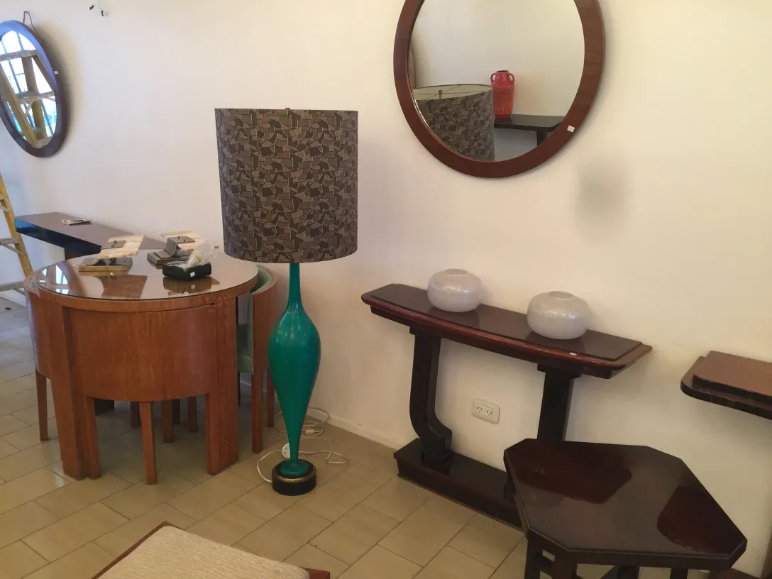 Antique floor lamp with green base and decorative shade in a cozy setting.