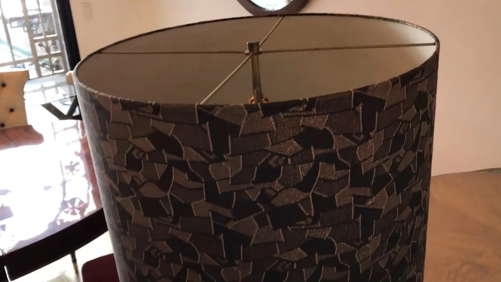 Lámpara de pie antigua con diseño elegante y texturas únicas en un ambiente acogedor.