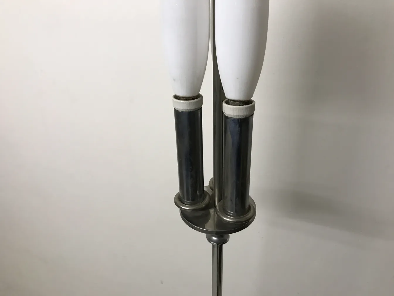 Antique floor lamp with two bulbs on a sleek metal stand.