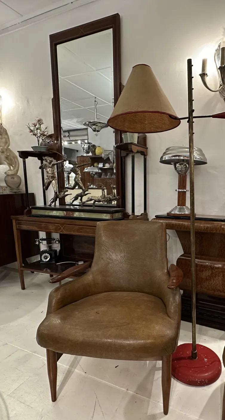 Lámpara de pie antigua con pantalla en forma de cono y base roja, ambiente vintage con muebles de época.