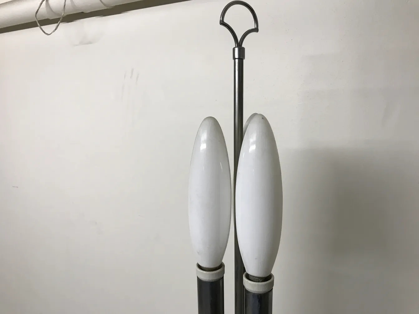 Antique floor lamp with two curved white bulbs, neutral setting.