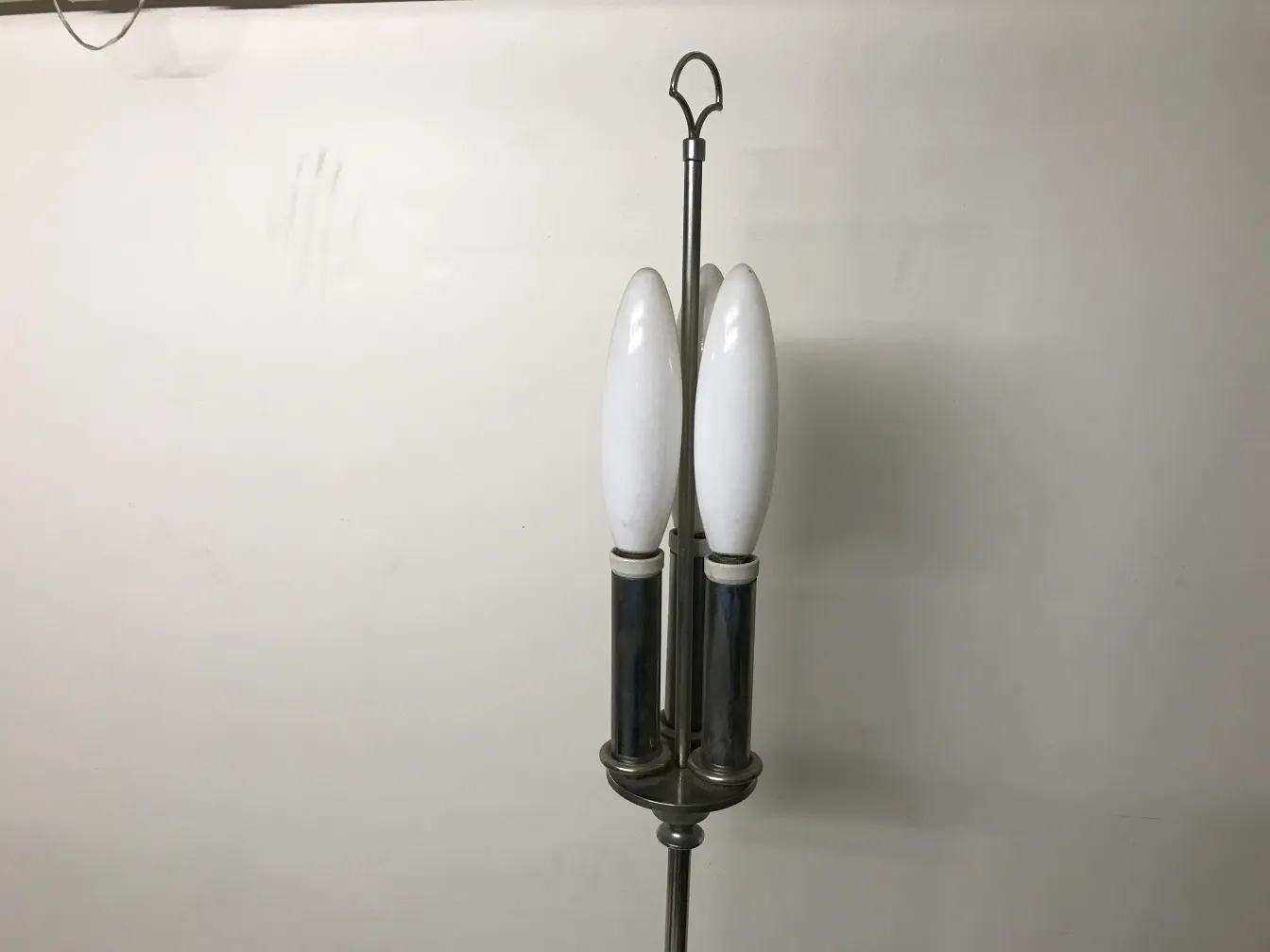 Antiga luminária de pé com duas lâmpadas brancas em um ambiente elegante.