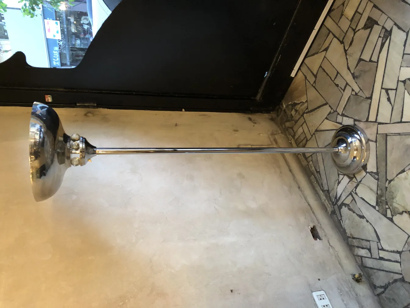 Lámpara de pie antigua con base brillante, en un ambiente acogedor.