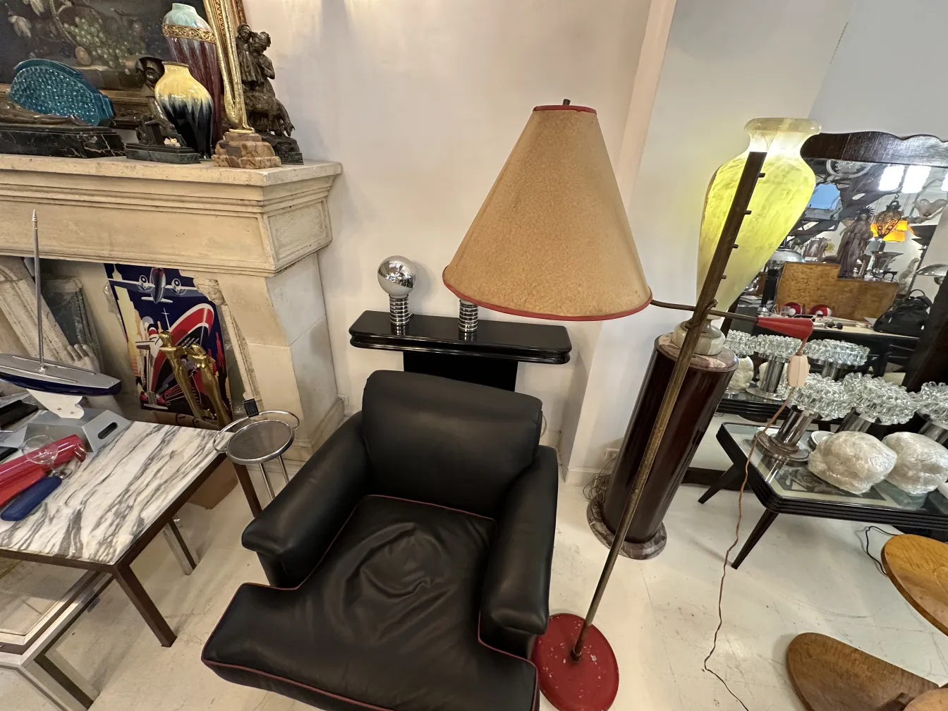 पुराना-फर्श-का-दीपक-से-बेज-छाया-एक-काले-सोफे-और-विभिन्न-शिल्पों-के-साथ.