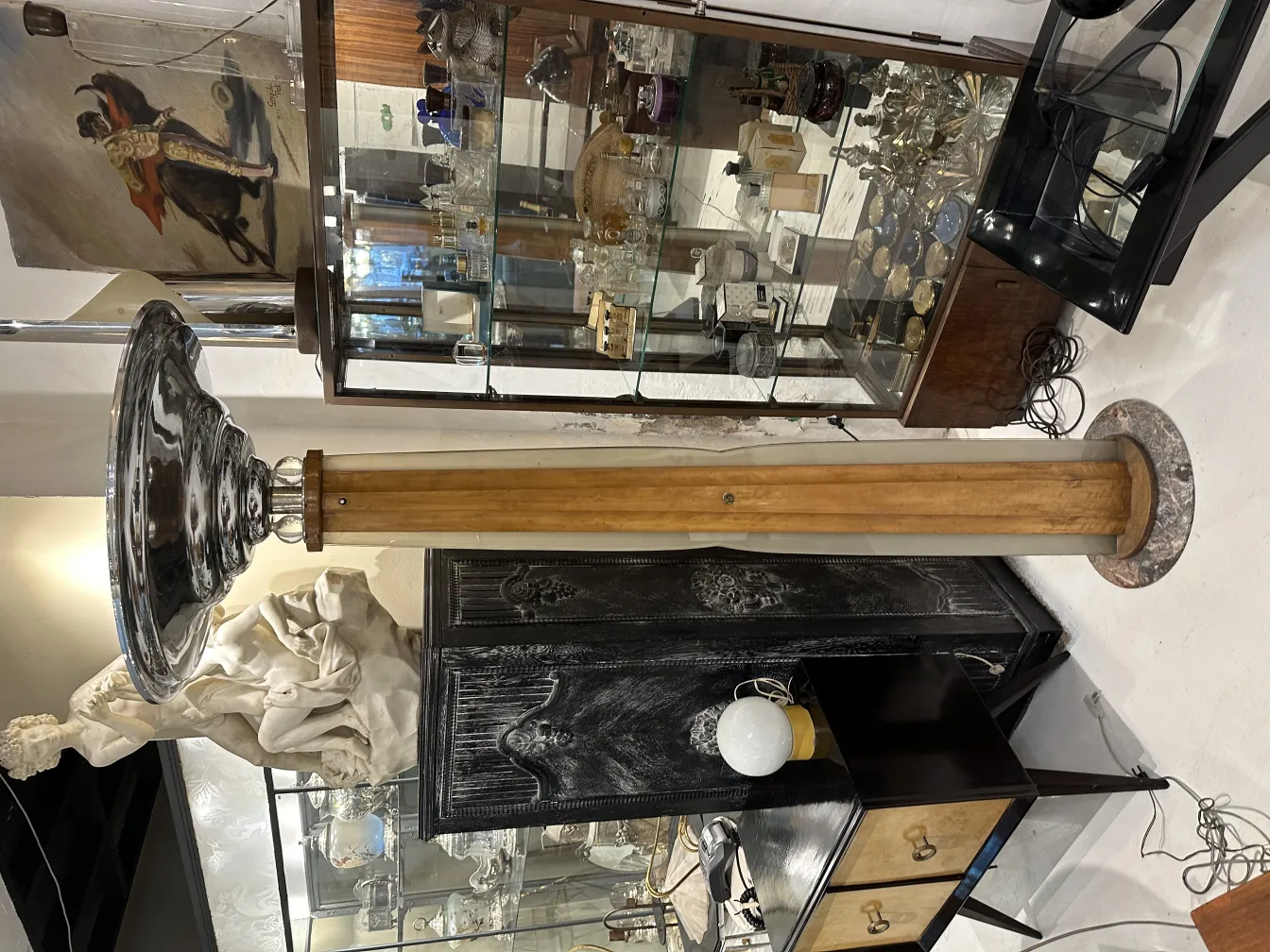 Lampada da terra antica con base rotonda e paralume metallico.