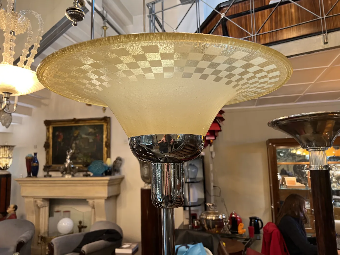 Lámpara de pie antigua con pantalla de cristal en un ambiente elegante.