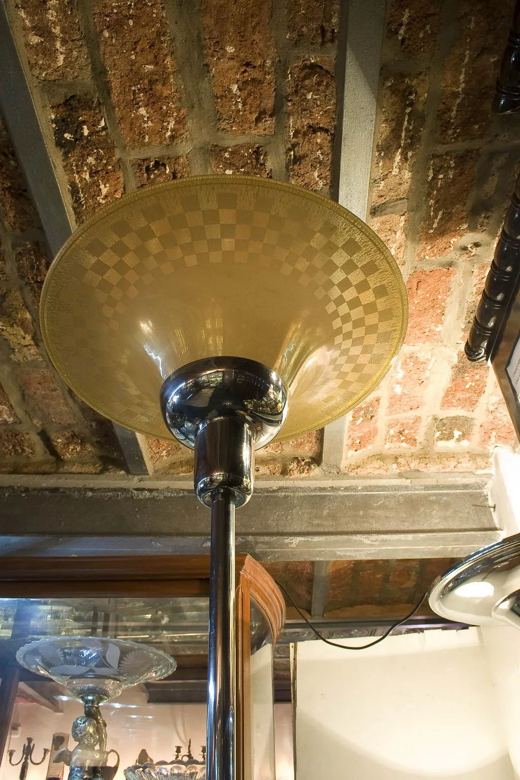 Lampada da terra antica con paralume in vetro decorativo in un ambiente rustico