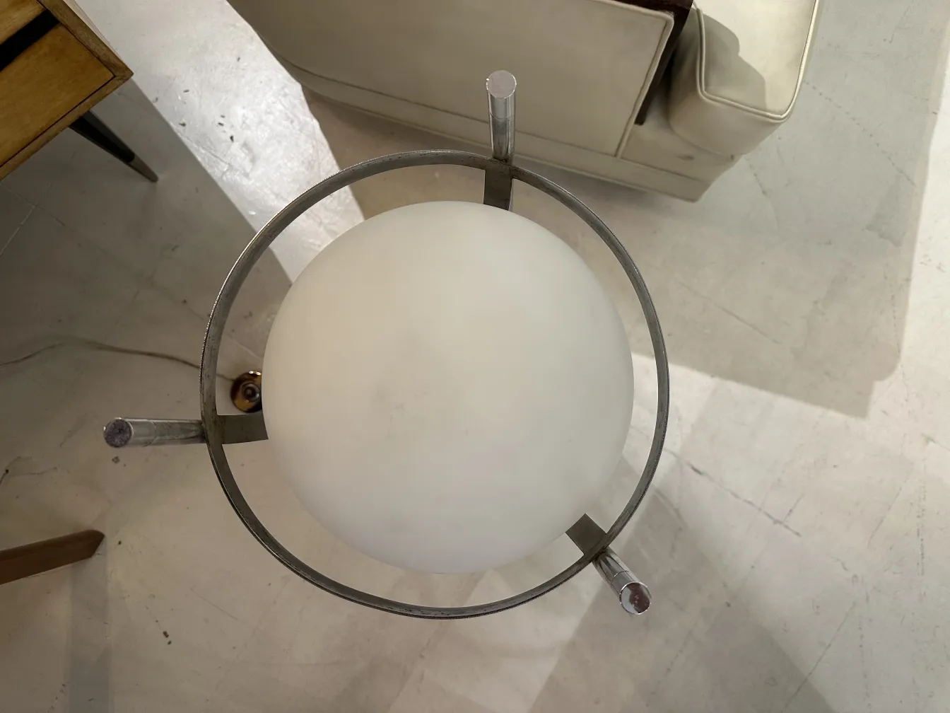 Lampada da terra antica con sfera bianca in un ambiente moderno.