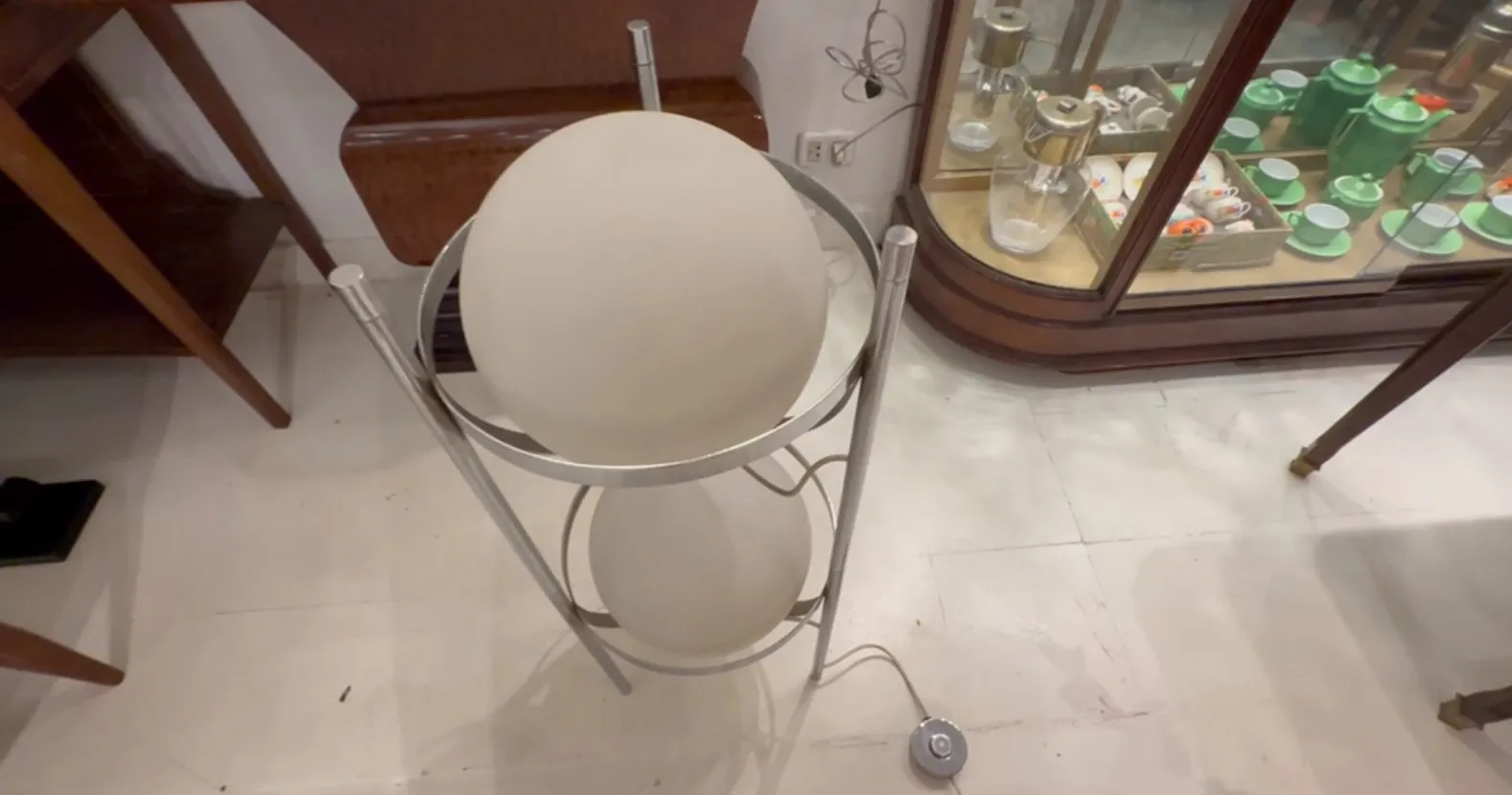 Luminária de pé antiga com esfera de vidro em interior elegante.