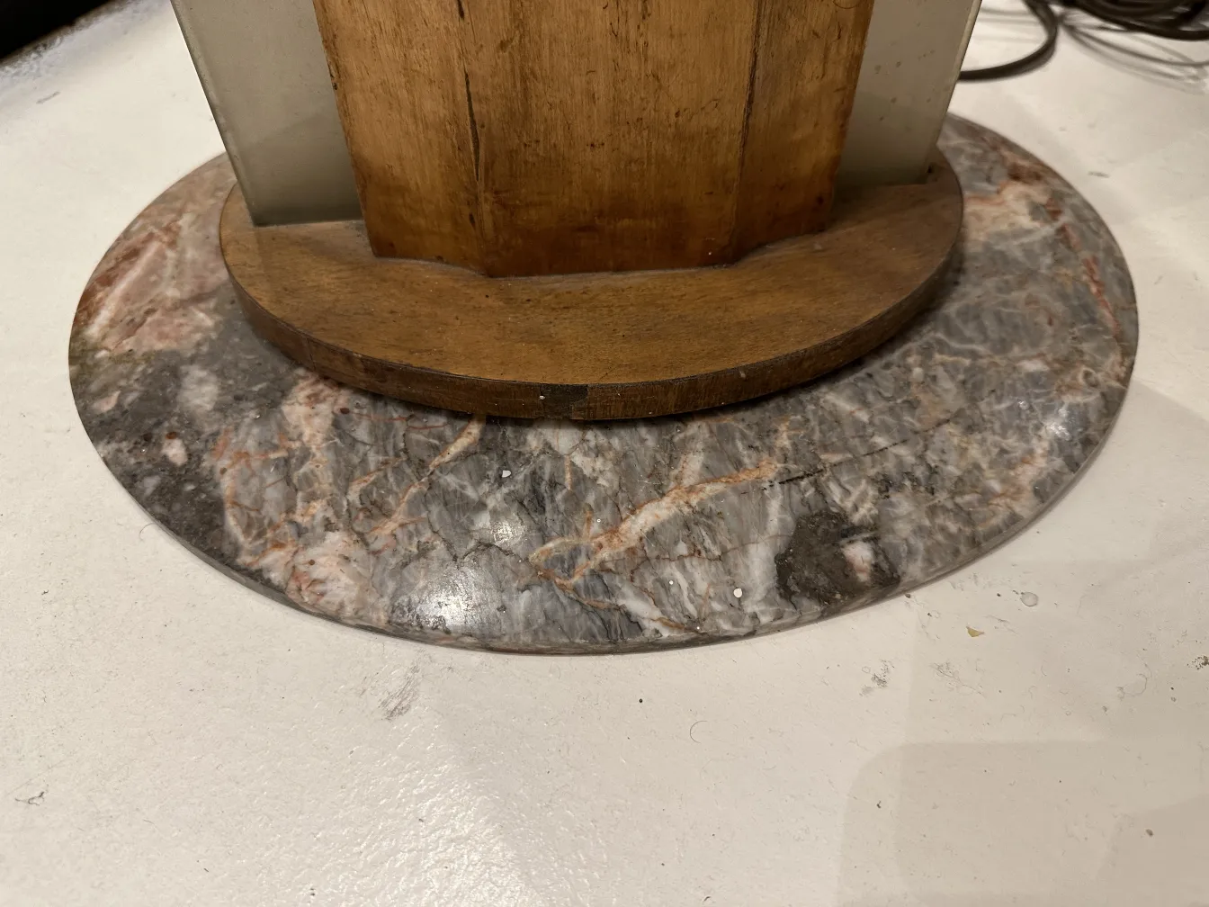 Lampe de sol ancienne avec base en marbre et détails en bois, dans un cadre neutre.