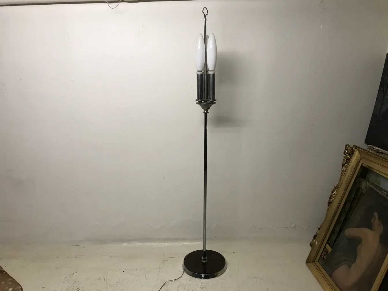 Antiga luminária de pé na sala, com duas lâmpadas brancas.