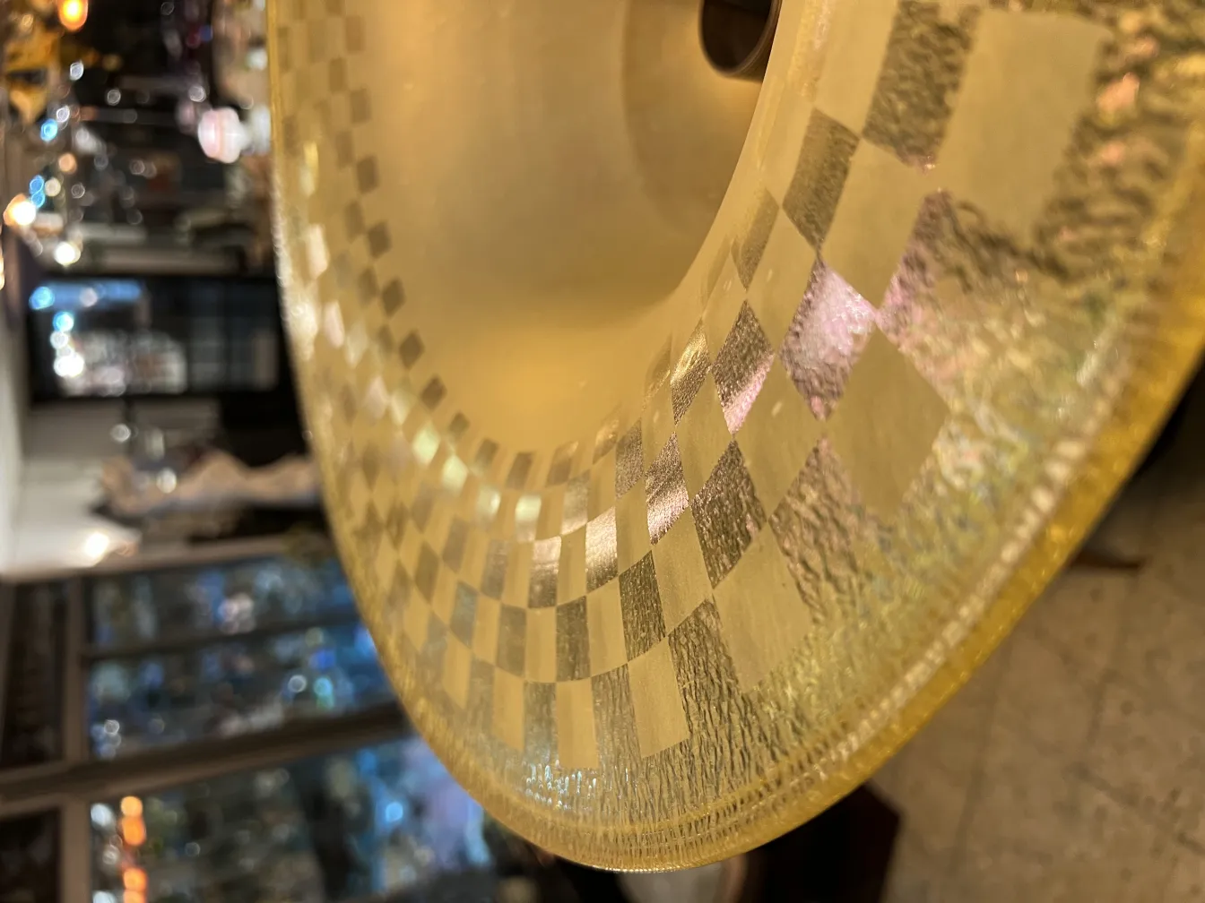 Lámpara de pie antigua con base decorativa y acabado brillante, en un entorno con objetos elegantes.