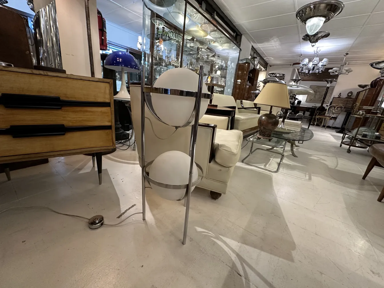 Luminária de pé antiga com base elegante e cúpulas redondas em um ambiente aconchegante.