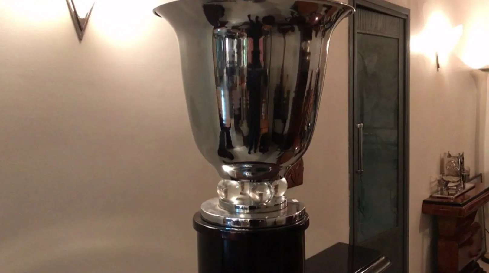 Antike Stehleuchte mit glänzendem Finish und eleganter Basis, die einen gemütlichen Raum beleuchtet.