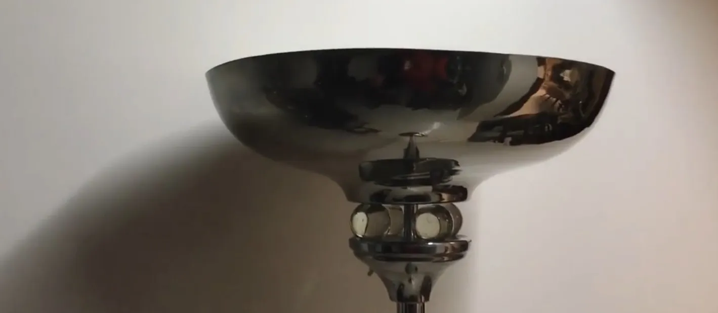 Luminária de pé antiga com design minimalista e cúpula refletora, em um ambiente aconchegante.