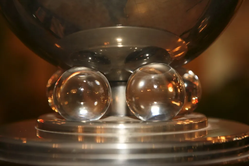 Lampada da terra antica con base di sfere in vetro lucido in un ambiente caldo.