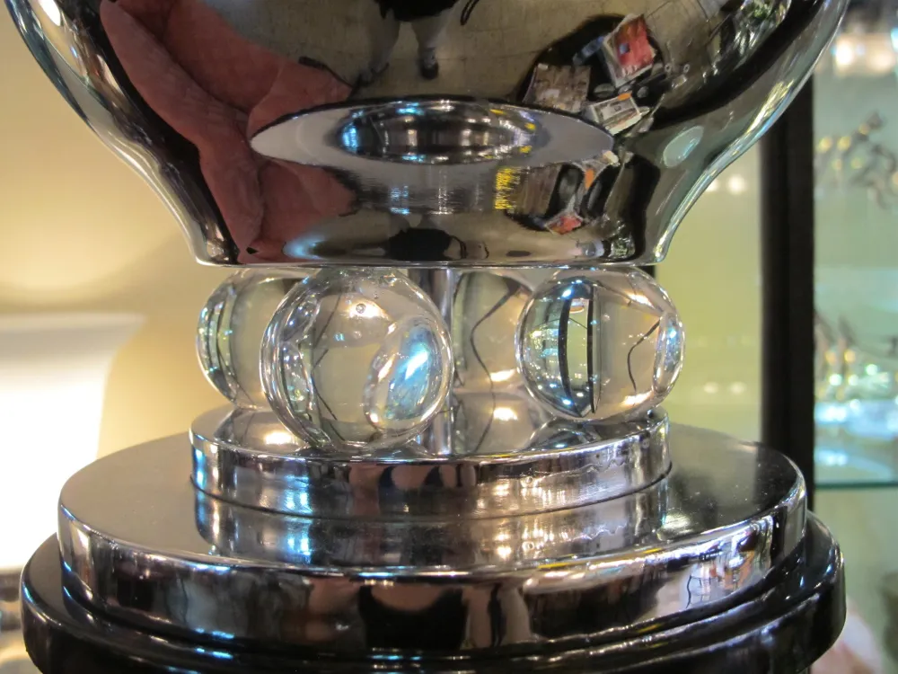 Lampada da terra antica con base rotonda in vetro, che brilla dolcemente in un ambiente elegante.