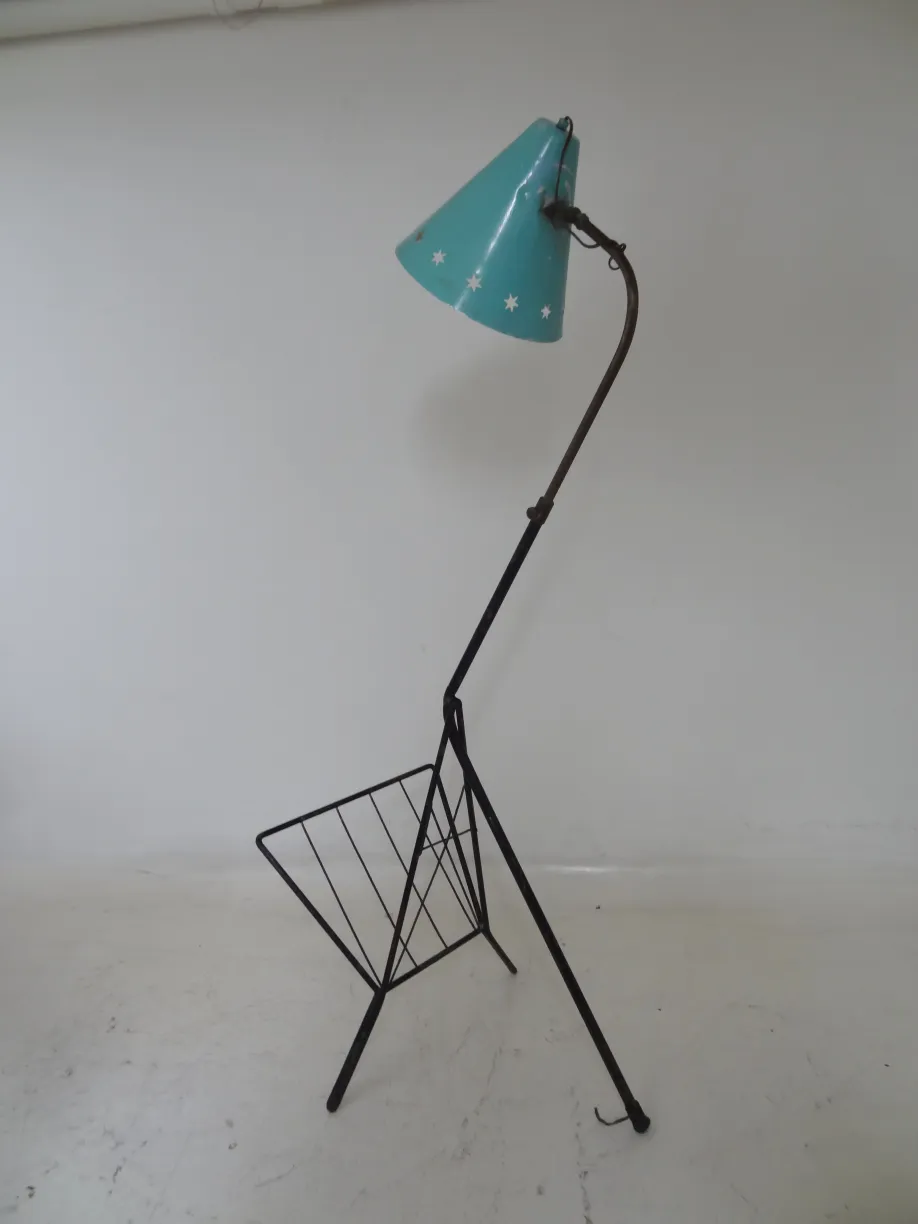 Lampada da terra antica con paralume blu e design elegante in un ambiente neutro.