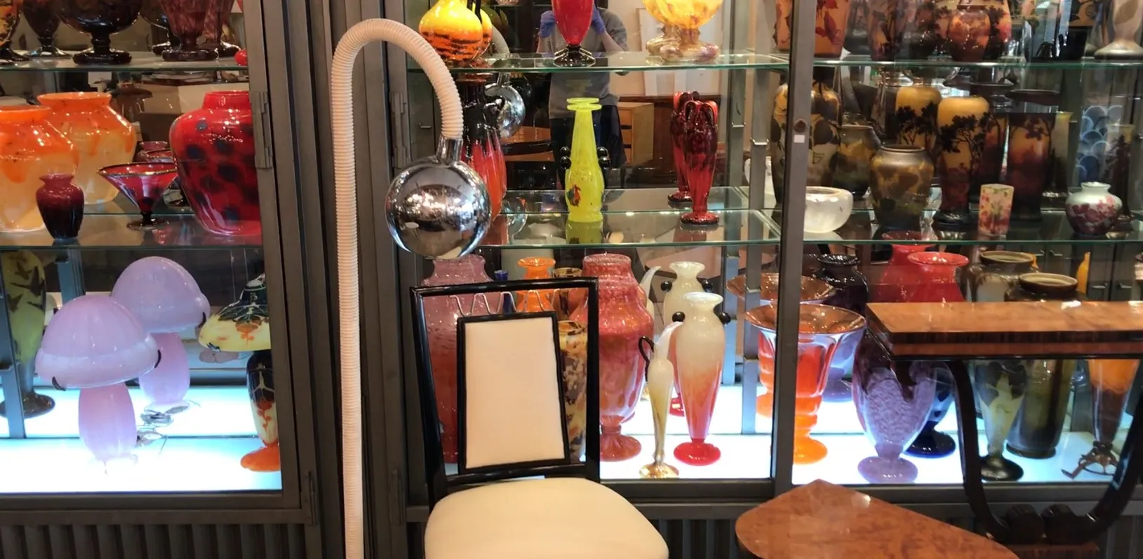 古董落地灯，优雅的设计和光亮的球，周围是五颜六色的玻璃花瓶。