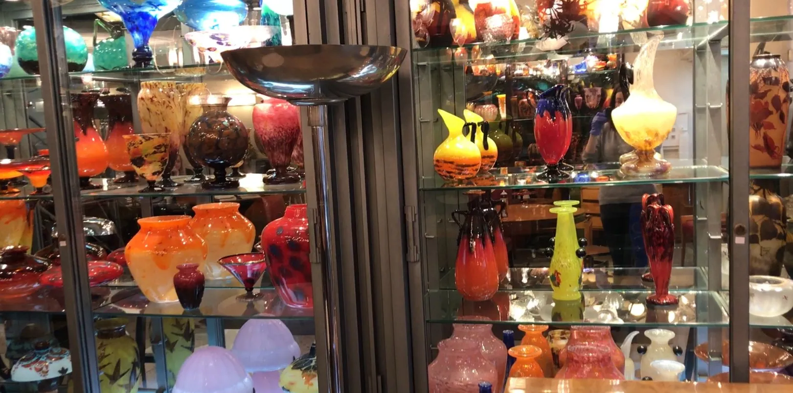 Lampada da terra antica tra colorati vasi di vetro