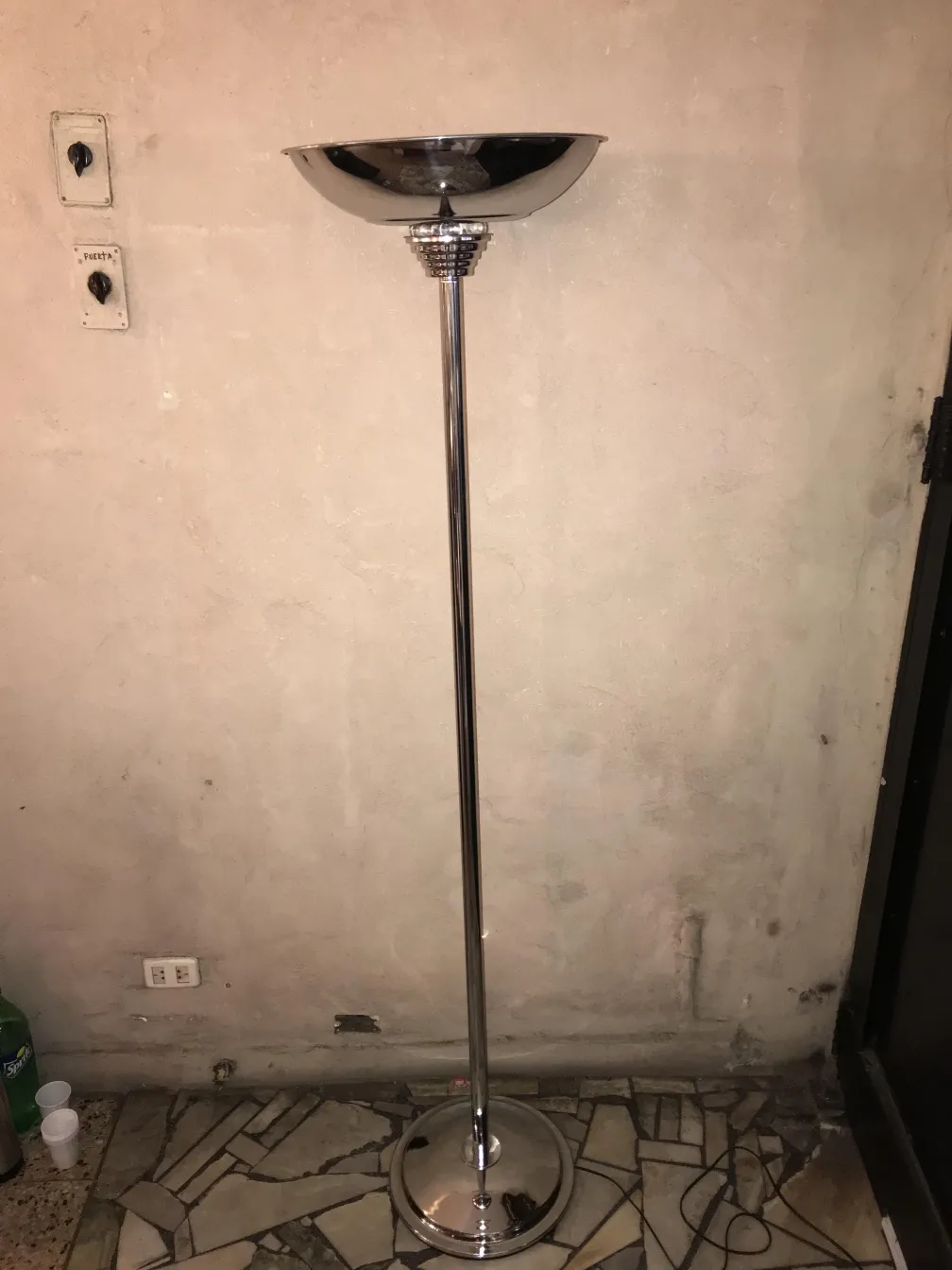 zwei antike, glänzende Stehleuchten in einem schlichten Umfeld.