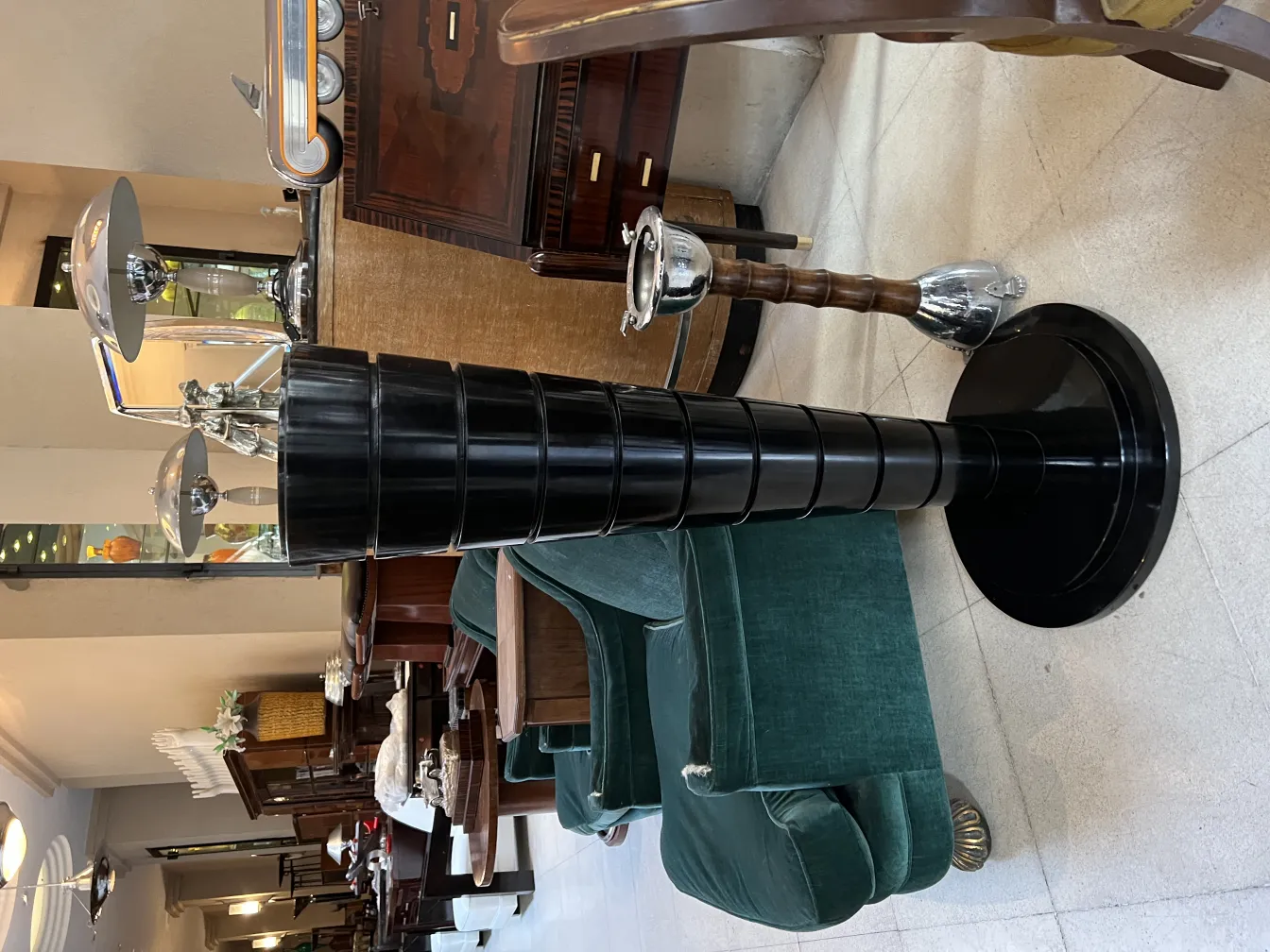 due lampade da terra antiche in un ambiente elegante con poltrone verdi e decorazioni vintage