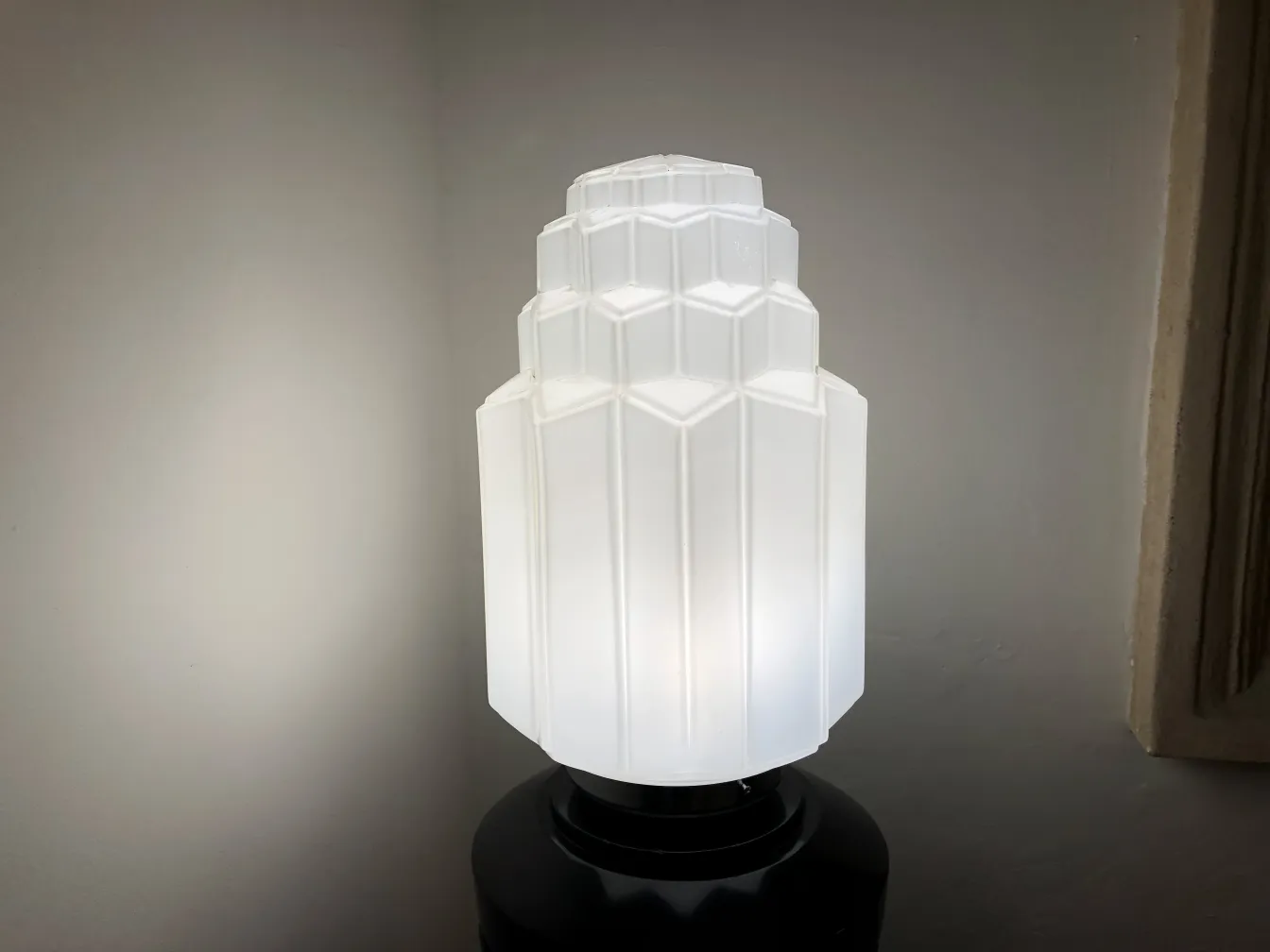 Lampadaire ancien avec abat-jour blanc et design unique, dans un cadre accueillant.