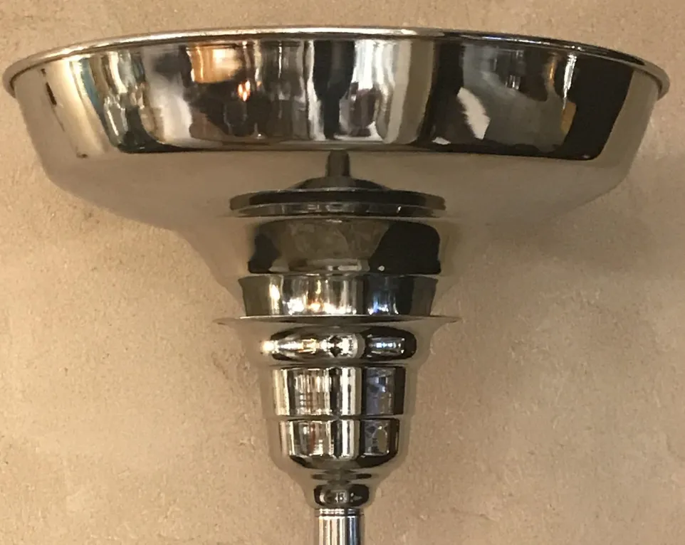 View of 2 antique floor lamps with shiny bases and elegant details.