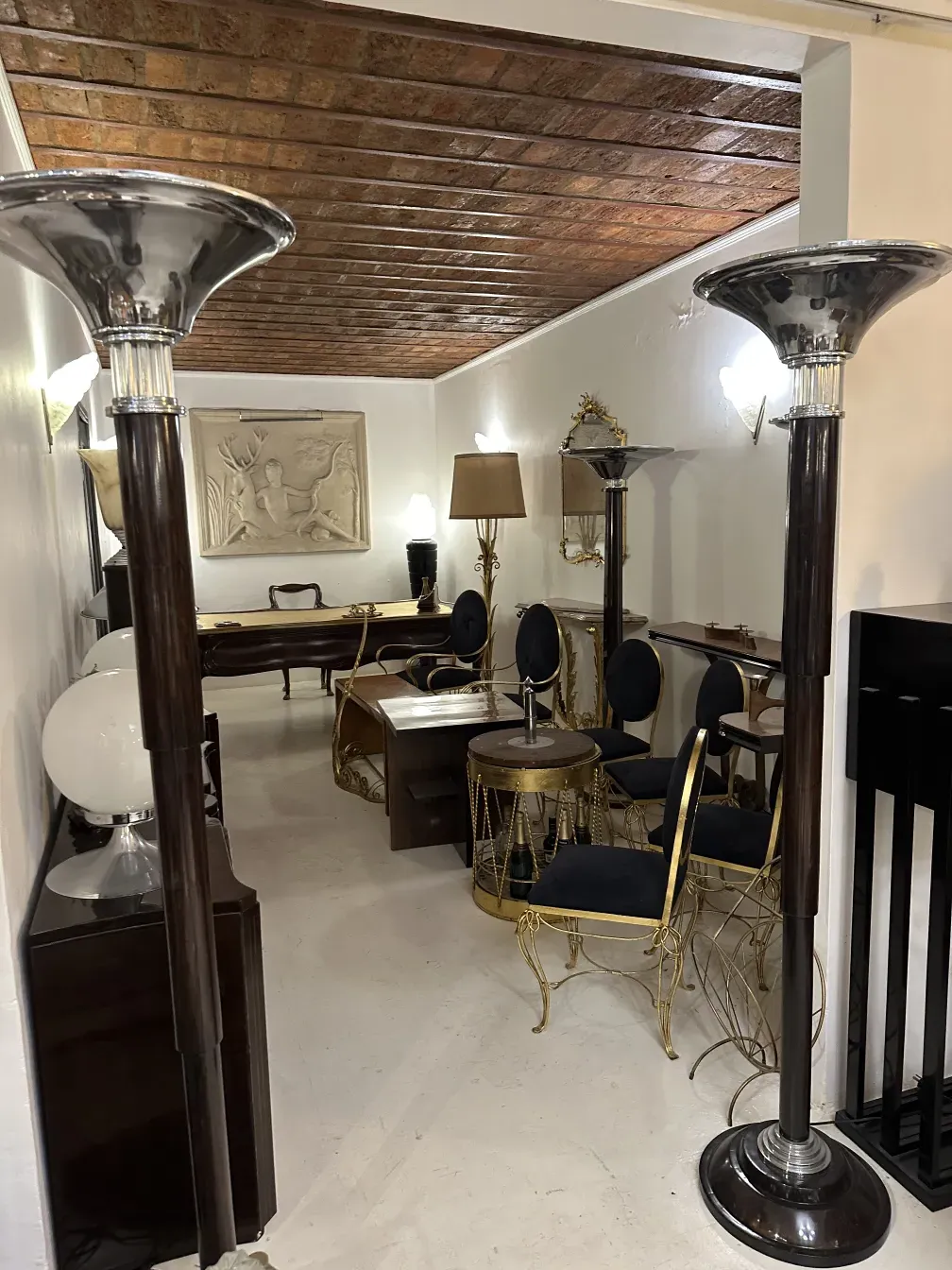 Conjunto de 2 lámparas de pie antiguas en una habitación con muebles.