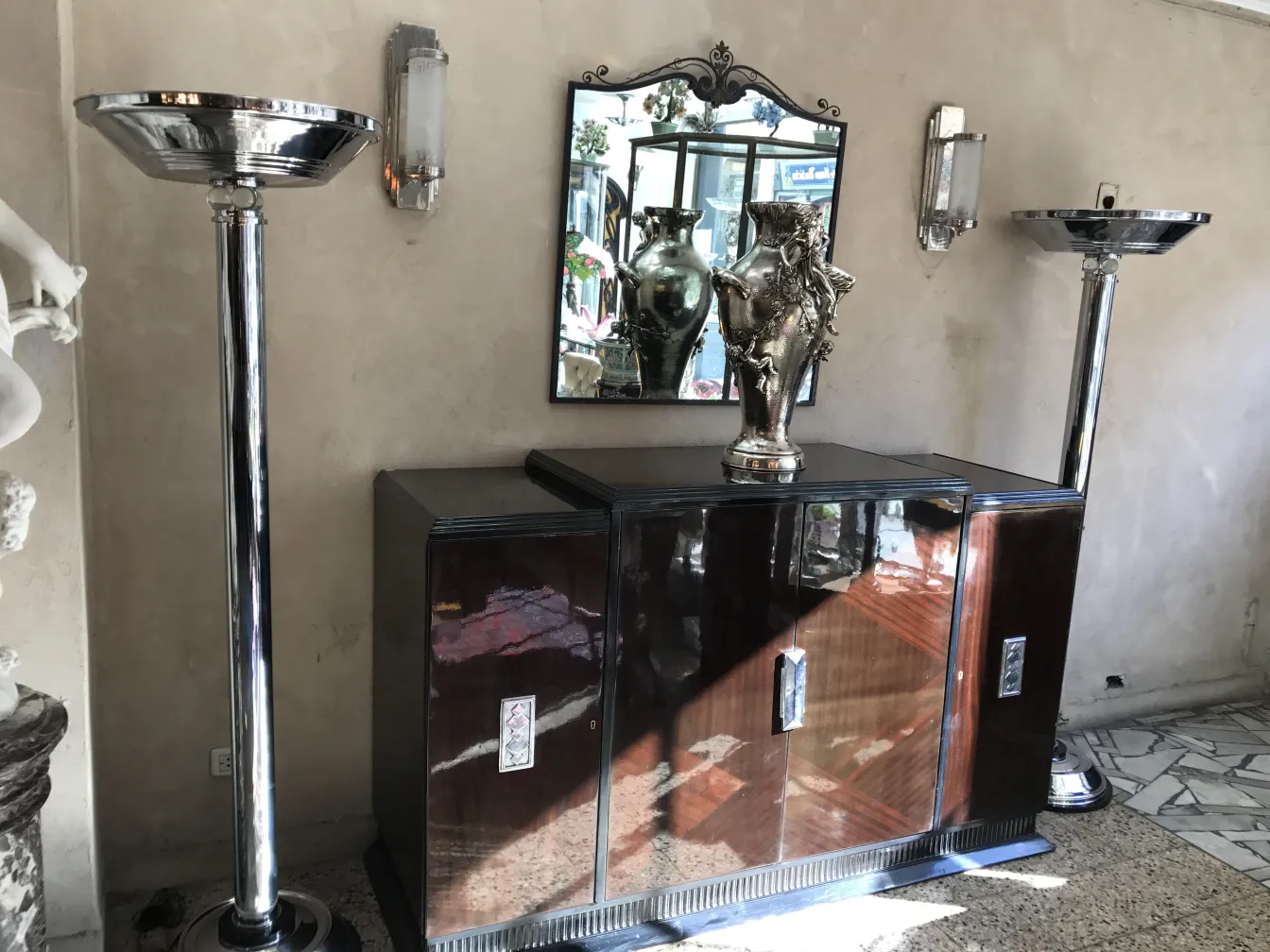 two antique floor lamps in an elegant environment, decorated with a mirror and a sculpture