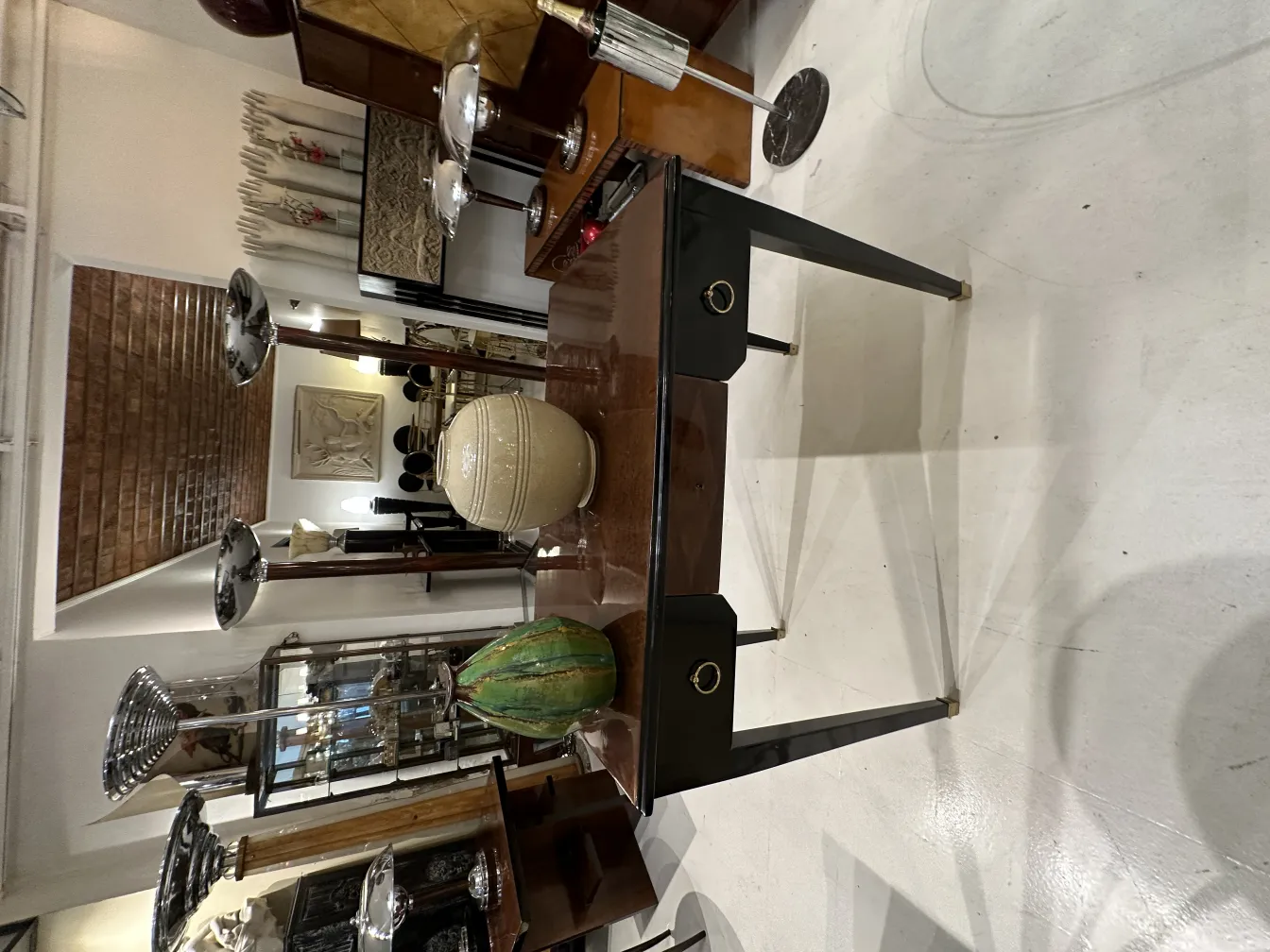 Duas lampadas de piso antigas em um ambiente elegante, com uma mesa e decorações