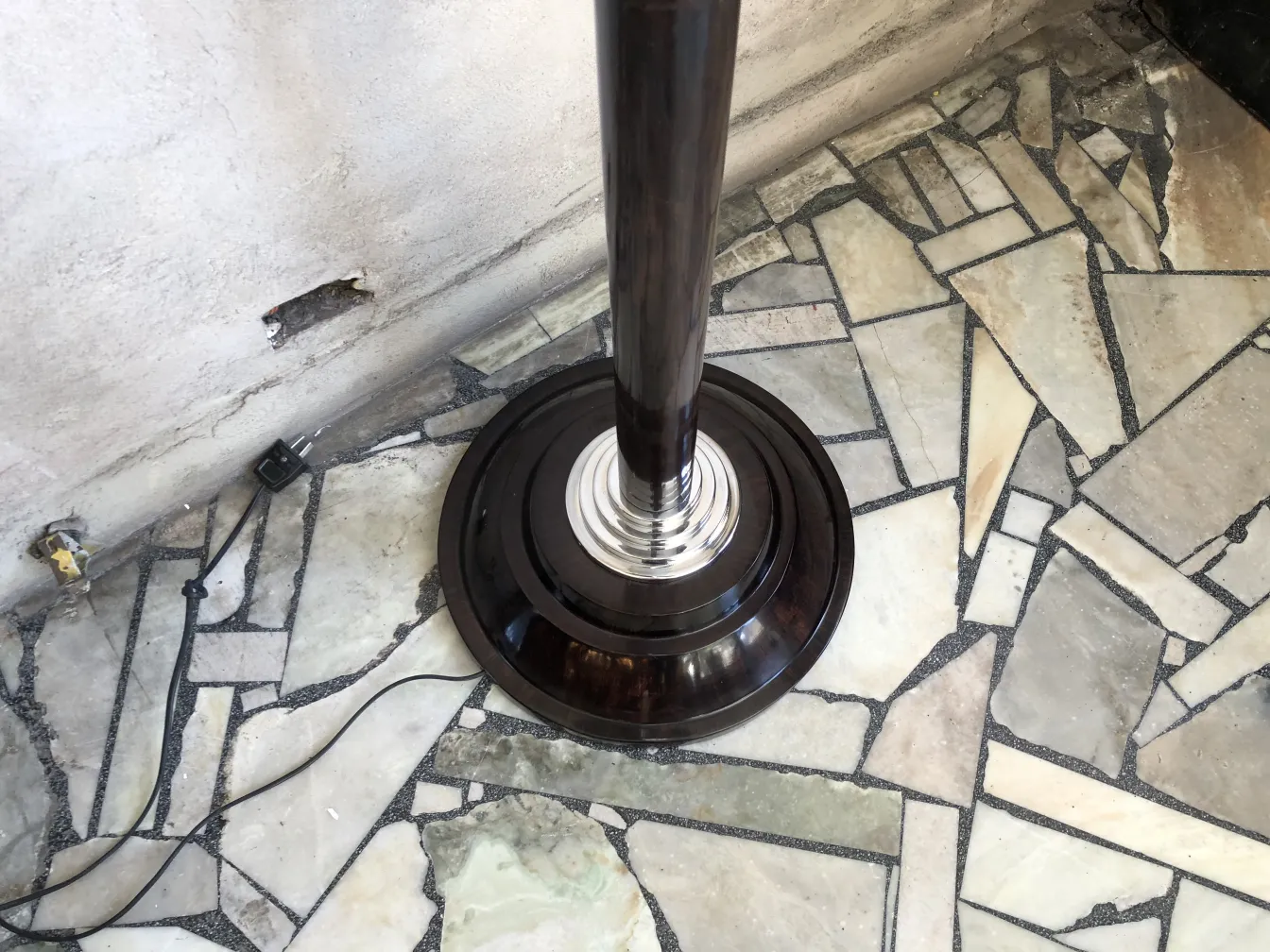 2 lâmpadas de piso antigas em um ambiente com piso de pedra.